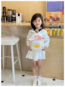Détail du sac à dos blanc à paillettes pour enfants avec couronne dorée et ailes d'ange