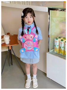 Pink preschool backpack with sequin butterfly wings shown by a girl in a cafe