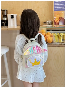 Détail d'un sac à dos blanc pour enfant avec ailes irisées et écusson couronne Sweet