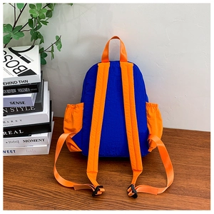 Detail of color-block kids backpack with orange side mesh pockets and adjustable buckles