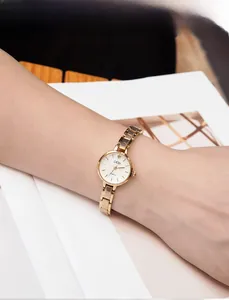 Close-up of elegant gold alloy bracelet watch worn on wrist with luxury minimalist dial