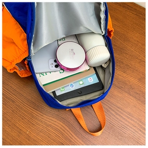 Detail view of large capacity kids backpack interior with books, tablet and water bottle