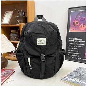 Détail du sac à dos en nylon noir imperméable avec fermeture à boucle et étiquette montagne