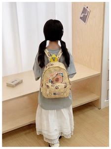 Rear view of a child wearing the cute Kapibara print backpack in a cozy room setting