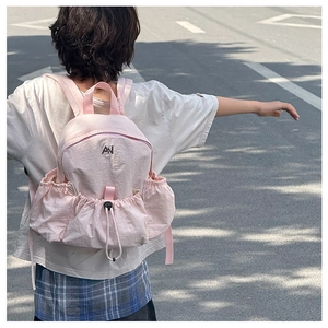 Detail of pink children's backpack with AN logo and adjustable drawstring side pockets