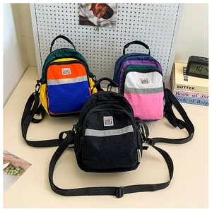 Detail of colorful mini backpacks with reflective strips and adjustable nylon straps