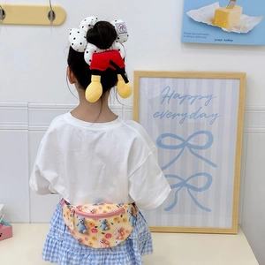 Enfant portant une sacoche banane jaune avec ours en peluche 3D et chouchou à pois