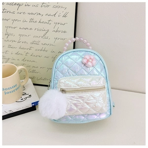 Detail of laser gradient quilted backpack with beaded handle and plush pompom charm