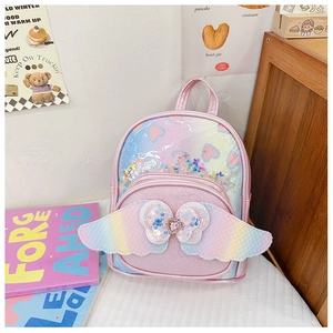 Detail view of pink sequin kids backpack with rainbow wings and a heart gem ornament