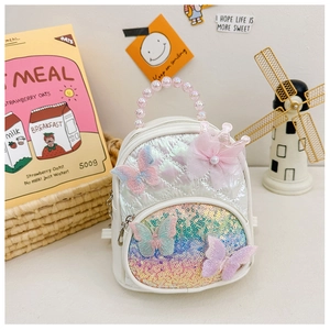 Close-up of quilted children's backpack with sequins, pearl handle and lace butterfly detail