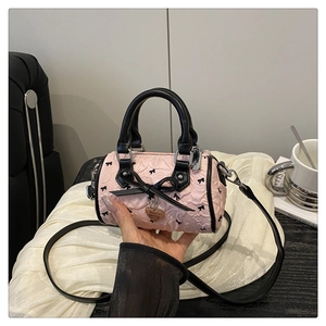 Detail of pink embossed mini Boston bag with black bows and golden heart plate