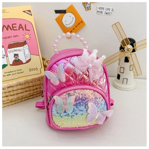 Detailed view of pink quilted backpack featuring lace crown, pearl handle and sequins