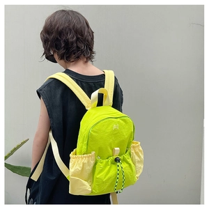 Detail of lightweight neon nylon backpack with contrast drawstring pockets and embroidery