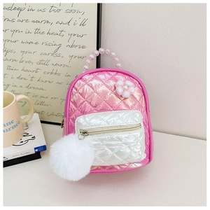 Detail showing iridescent pink quilted kids backpack with pearl handle and pom-pom charm