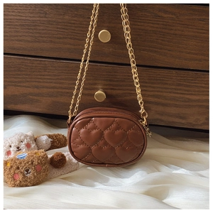 Dettaglio della mini borsa trapuntata a cuore marrone con catena dorata su seta vintage