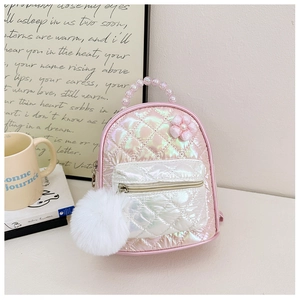 Close-up of quilted pink kids backpack featuring beaded handle and white pom-pom charm