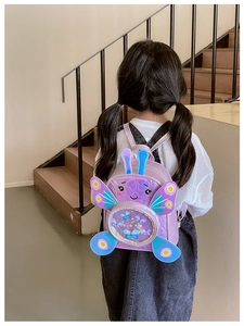 Close-up of cute purple butterfly backpack with shiny sequins and a transparent pocket