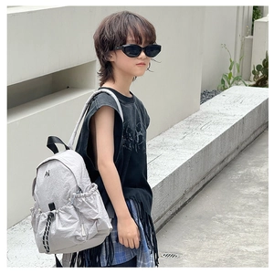 Close-up of light gray children's nylon backpack with AN logo and side drawstring pocket