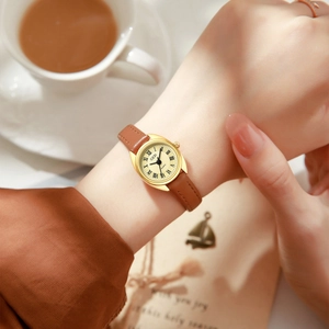 Montre rétro élégante pour femmes avec boîtier doré ovale et bracelet en cuir marron