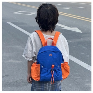 Detail of blue and orange kids backpack with drawstring pocket and embroidered AN logo