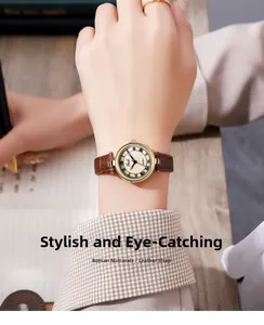 Gros plan d'une montre vintage en or avec bracelet en cuir marron sur le poignet