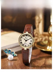 Gros plan d'une montre vintage à quartz avec cadran en nacre et bracelet en cuir marron