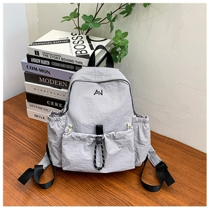 Detail of grey nylon kids backpack with AN embroidery and functional drawstrings