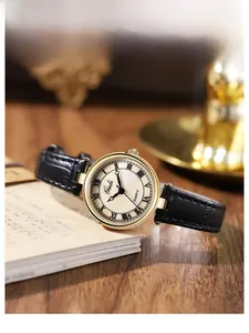 Détail macro d'une montre à quartz avec boîtier doré, cadran nacre et bracelet cuir noir