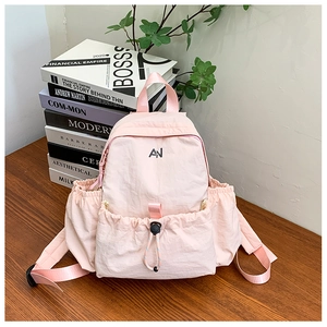 Detailed macro view of the light pink nylon school bag showing the drawstring pocket and logo