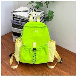 Detail of neon green and yellow kids backpack with drawstring pocket and nylon texture