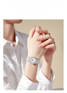Close-up of minimalist GEDI quartz watch with silver case and gray leather strap for women