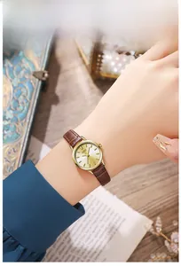 Detail of GEDI women watch with brown leather strap and elegant gold dial on wrist