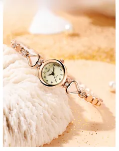 Vue rapprochée d'une montre à quartz rose gold avec bracelet cœur sur socle de corail