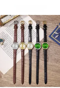 Collection of elegant leather strap watches for women in varied dial colors on a vintage desk