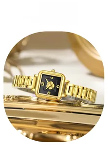 Detail of golden square watch with black floral dial and polished steel bracelet