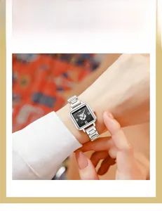 Detail of square silver watch with black dial featuring a silver camellia floral motif