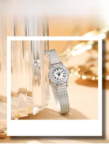 Gros plan sur une montre rétro argentée avec gravures florales et cadran blanc élégant