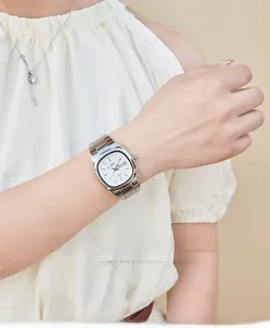 Close-up of elegant silver quartz watch with white oval dial and date-day display