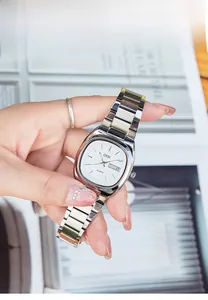Close-up of elegant oval quartz watch with steel band and day-date window on wrist