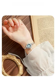 Detail of elegant silver bracelet watch with light green dial and Roman numerals