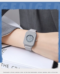 Close-up of minimalist grey square watch with silicone strap worn on wrist