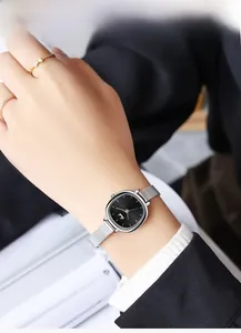 Close-up of elegant square dial watch with silver mesh strap on woman's wrist