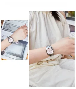 Close-up of women's quartz watch with pink dial, silver steel band and day-date window