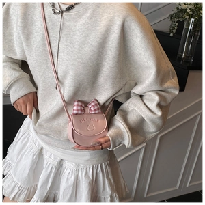 Detail of cute pink crossbody bag featuring a red plaid bow and embroidered cat motif