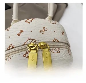 Detail of premium golden dual zipper and cute cat print on cream leather backpack