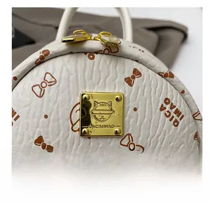 Close-up of litchi texture faux leather with cute cat print and golden metal logo plate