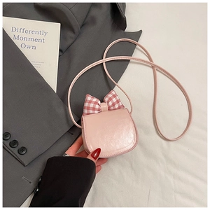 Pink mini crossbody bag featuring a cute red checkered bow and sleek leather strap