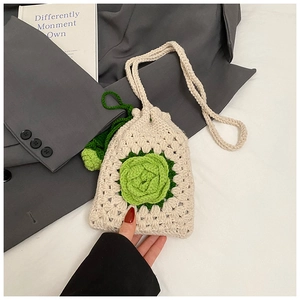 Detail der handgehäkelten Schultertasche mit grüner 3D-Blume und Kordelzug-Verschluss