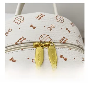 Detailed macro view of gold-tone smooth double zippers on the white cat print backpack