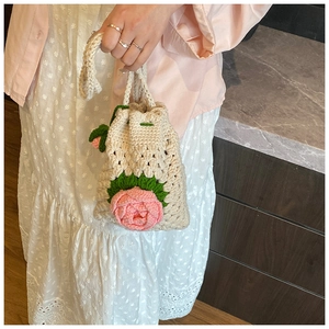 Detail der handgestrickten floralen Schultertasche mit 3D-Rose und Kordelzugverschluss